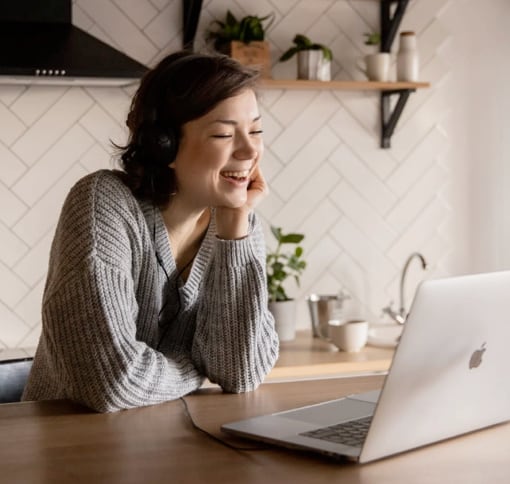 a laughing women in front of her laptop